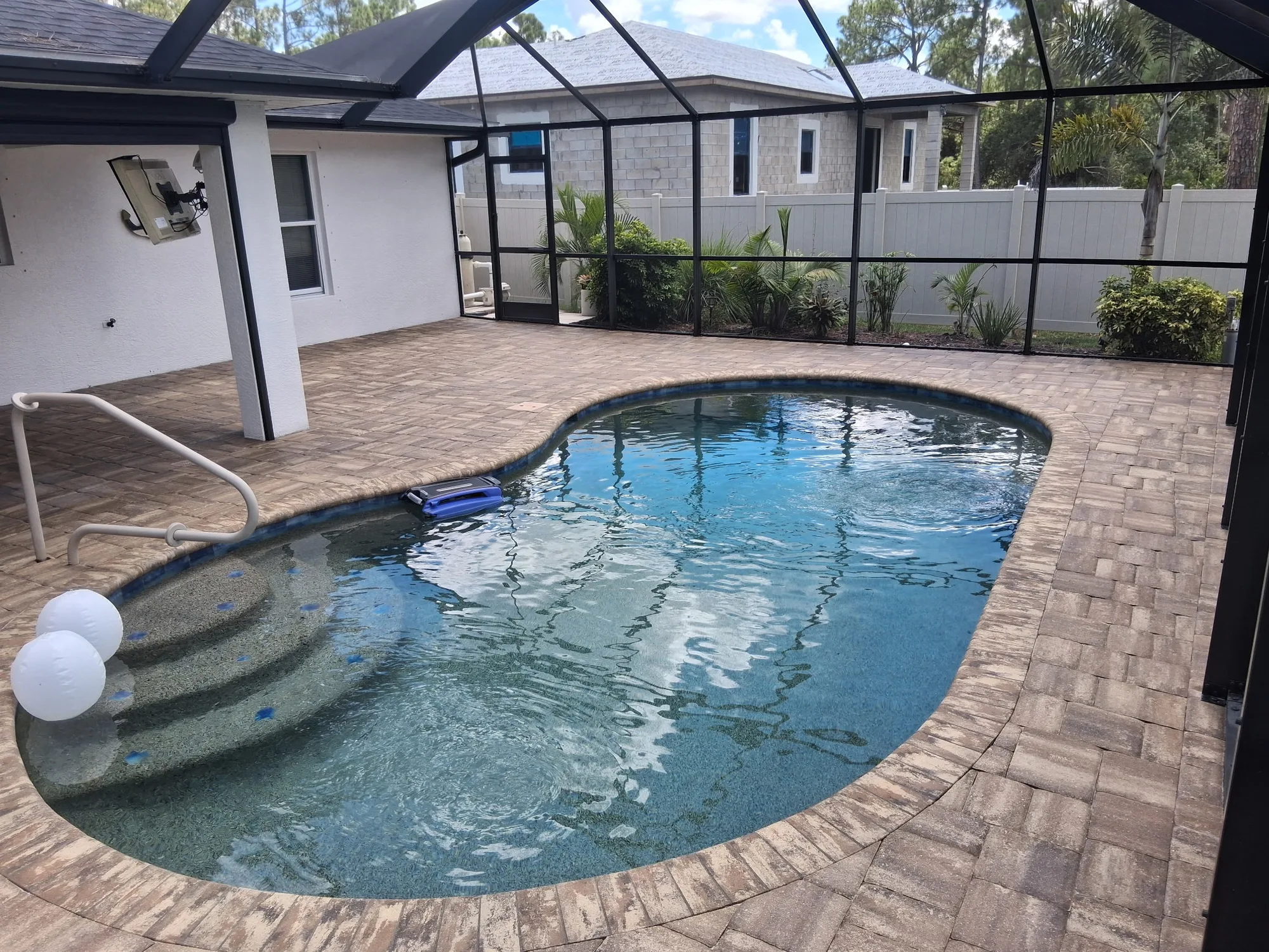 Sealed paver pool deck inside a screened pool cage in North Port, FL, after paver strip and restoration