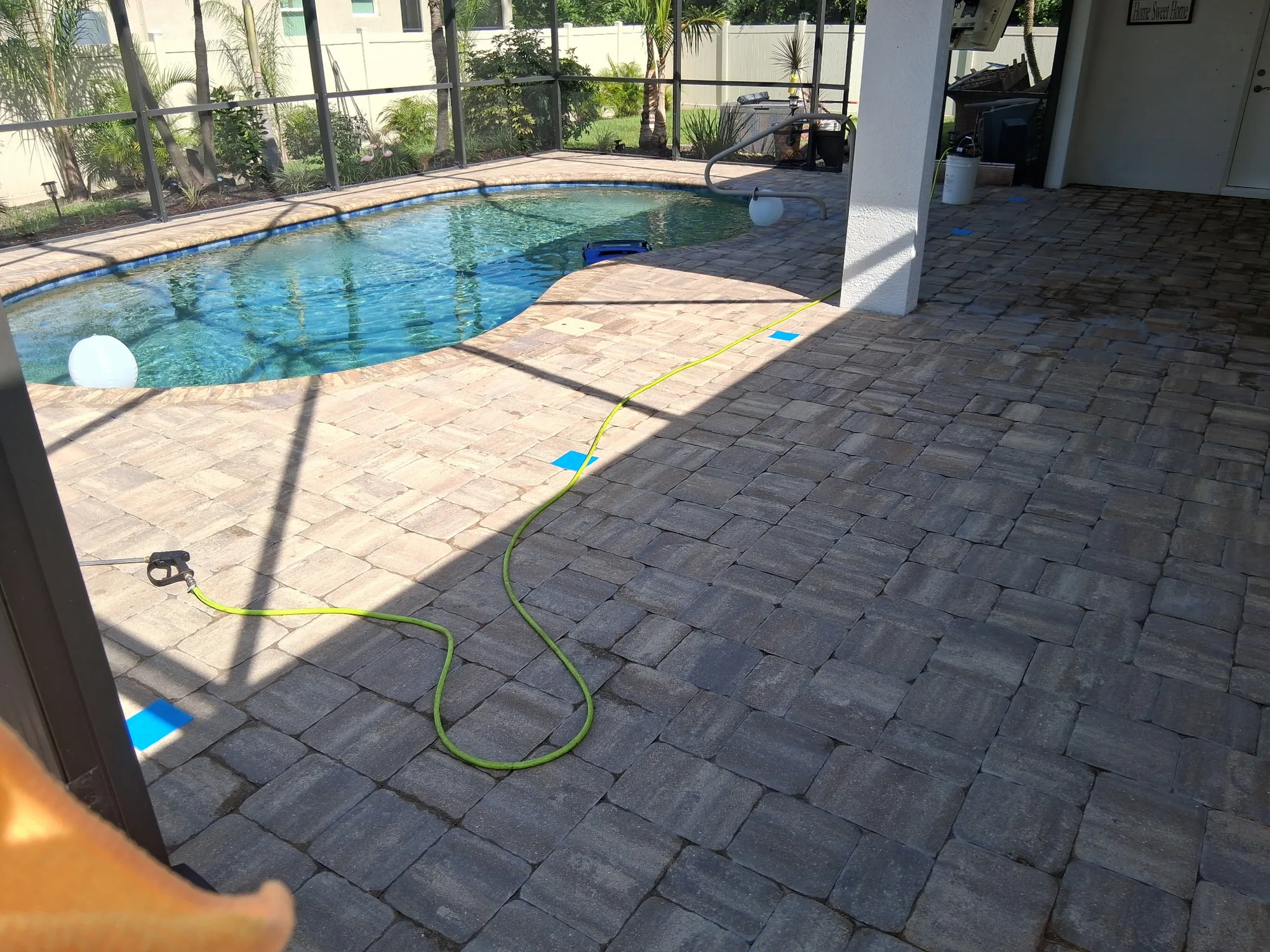 Paver pool deck and covered lanai in North Port, FL during strip prep, hose and pressure wand on the pavers